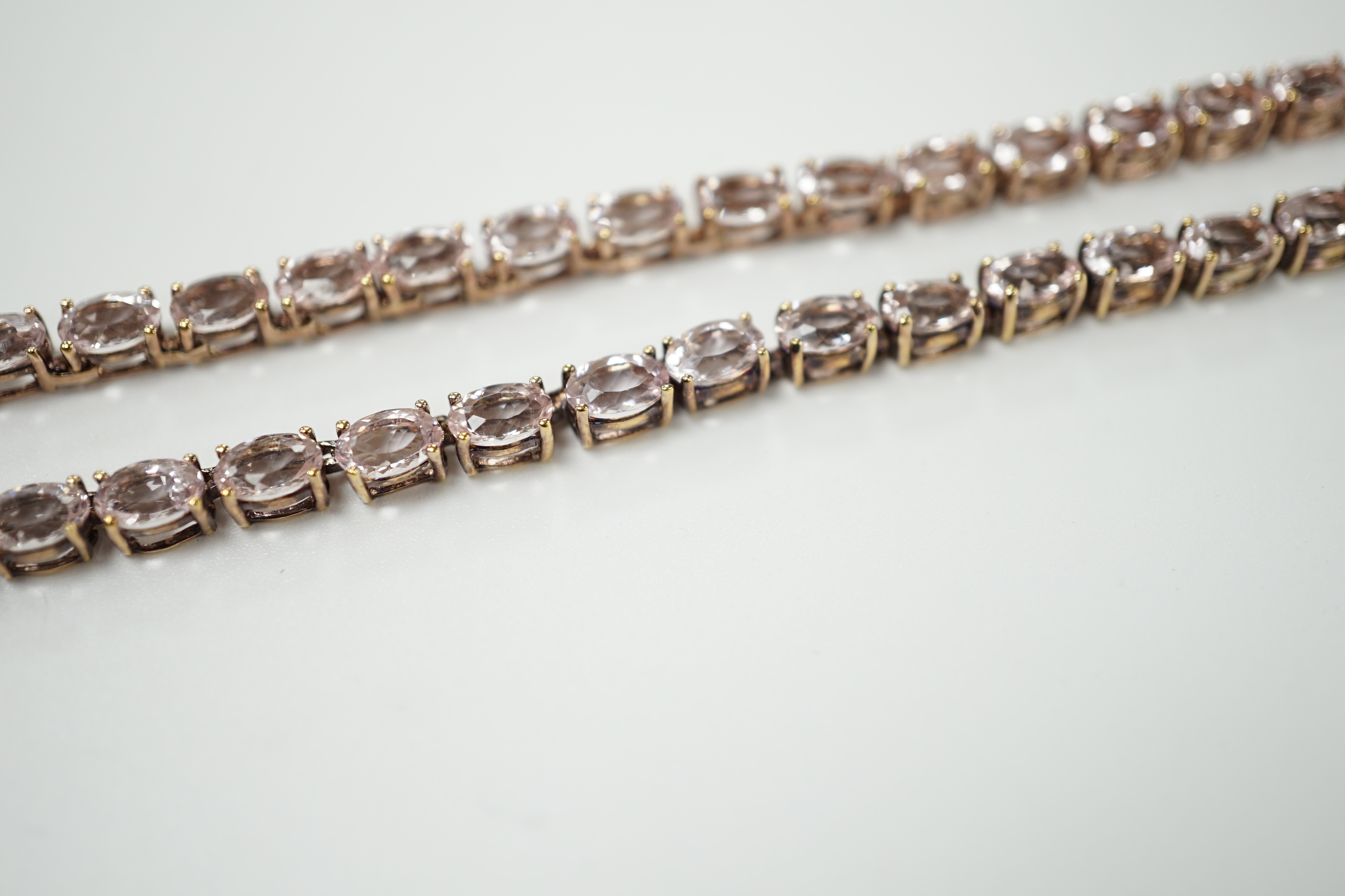 A modern 925 gilt metal and oval cut morganite set line necklace, 46cm.